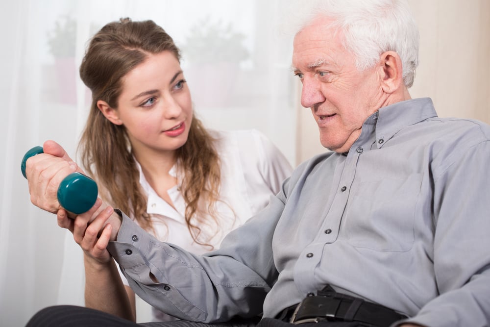 Older gentleman works on strength training with physical therapist