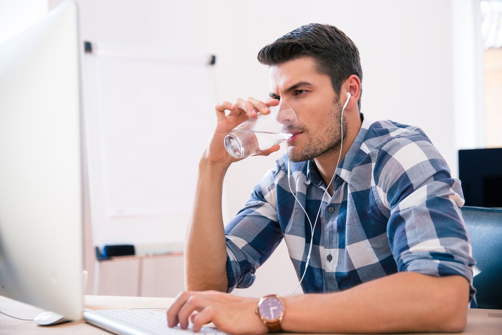 businessman in casual cloth using PC and drinking water in office